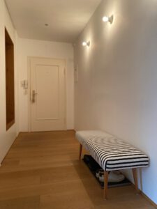Breiter, heller Flur mit Sitzgelegenheit