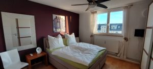 Großes Schlafzimmer mit bequemen Boxspringbett in möblierter Wohnung in München