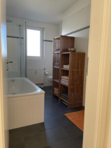 Bad mit Fenster, Badewanne und Dusche in möblierter Wohnung in München West