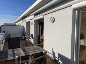 Grosszügige Dachterrasse mit Holzdielen und elektrischer Markise in möblierter Wohnung in München West